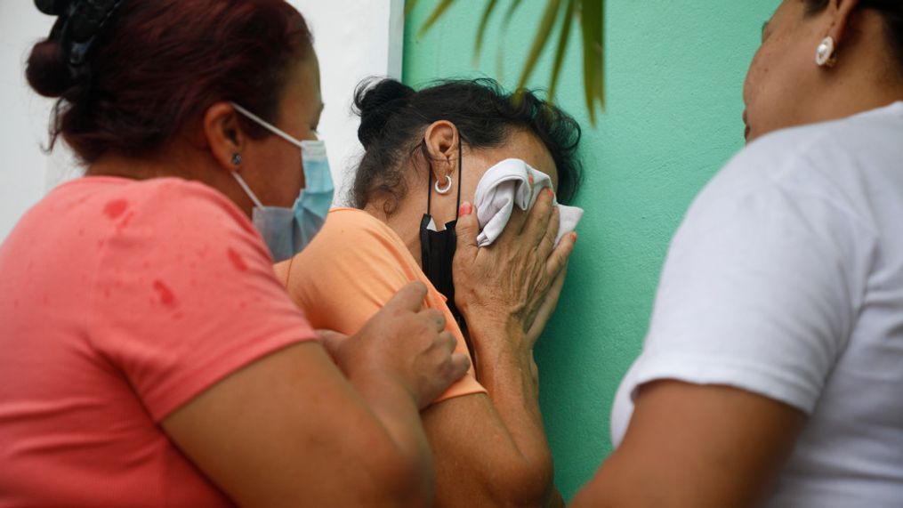 Relatives of inmates wait in distress outside the entrance to the women's prison in Tamara, on the outskirts of Tegucigalpa, Honduras, Tuesday, June 20, 2023. A riot at the women's prison has left at least 41 inmates dead, most of them burned to death, a Honduran police official said. (AP Photo/Elmer Martinez)